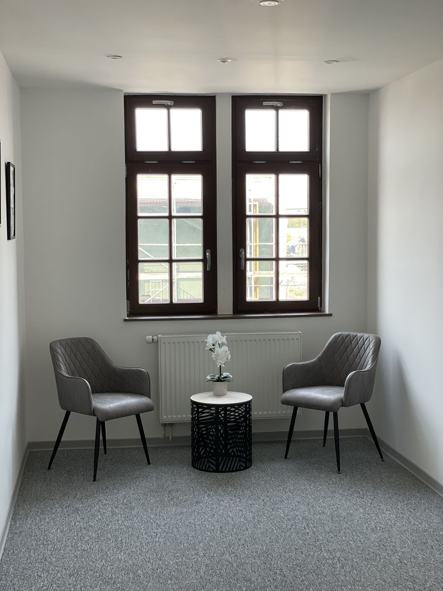 Flur mit Sitzecke vor historischen Fenstern